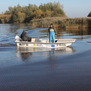 Following the fish, then emailing them: CANAPE researchers are catching and tagging bream in Lake de Leijan in the Nothern Netherlands. The researchers are tagging them with emails for fishermen to report back, and then setting them free. The tracking is used to inform fish and ecosystem management in shallow peatland lakes. Two people in a small white boat on a lake on a sunny day