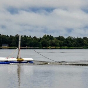 Predicting climate impacts: TOPSOIL uses an innovative floating device for 3D-mapping of structures 3070 m below the bottom of the lake. Photo: Aarhus University. A lake with people in a boat, towing a technical device that maps the underground structures below the lake.