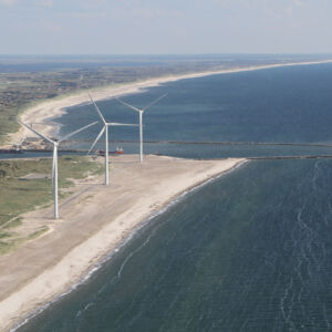 DUAL Ports: At the coast by the Danish port of Hvide Sande, three wind turbines produce sustainable energy for local district heating providing heat for the citizens. Coastal landscape along the North Sea with three large wind turbines.