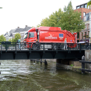 HyTrEc2: Fuel Cell waste-truck alongside bicycles on a scenic bridge. Like bicycles, Fuel Cell Vechicles are a sustainable transport solution. The only tailpipe emission from these innovative waste-trucks is water vapour! HyTrEc2 is one of the first projects in the world to try out this new technology in such large vehicles. HyTrEc2 is encouraging the take-up of hydrogen in transport by proving what our vehicles are capable of with extensive data monitoring. In fact, this model of fuel cell waste-truck is now being adopted by Interreg North West Europe project, HECTOR. Photo: Groningen (HyTrEc2 partner). A red hydrogen-fueled waste truck on a bridge.