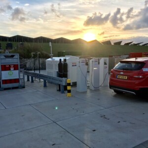 HyTrEc2: Fuel Cell car at a hydrogen refuelling station using solar powered electrolysis to generate fuel. Solar panels are seen in the background. HyTrEc2 encourages the adoption of renewable (green) hydrogen and is working across sectors to ensure the adoption of hydrogen technology into transport, looking not only at the vehicles themselves but also their fuel and its carbon-footprint. HyTrEc2’s green hydrogen solution means that well to wheel there is no carbon emissions! Photo: Groningen. Hydrogen charging station at sunset.