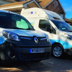 HyTrEc2: Two range-extended electric vehicles and a fuel cell car. The two vans are entirely bespoke and have had their range dramatically extended by including hydrogen. This revolutionary technology is important in the North Sea Region, which has a large remote hinterlands where unaided electric vehicles struggle to perform. All three vehicles are available for the public and businesses to trial, which increases awareness and encourages adoption. Photo: Aberdeen. Hydrogen fueled cars in a parking space.
