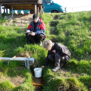 University Rostock measuring nutrients discharge in drainage water. This helps NuReDrain researchers developing a model to estimate the impact of new measures and filter systems to remove nutrients such as phosphorus and nitrogen in two contrasting catchments across the region. Researchers from the University of Rostock are measuring nutrients in discharge water on grassy slope.