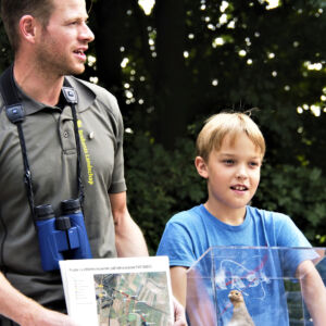 PARTRIDGE: Conservationist explaining, assisted by child: Project demo site manager Jochem Sloothaak is one of our best project communicators. Always full of energy and charisma, he works tirelessly to educate the public about how the PARTRIDGE project contributes to making his project region more wildlife-friendly and hence more enjoyable for everyone visiting the area, but especially the people living in the area. Photo: Ernst Jan van Haaften Conservationist and boy explaining about measures to conserve biodiversity in farmlands.