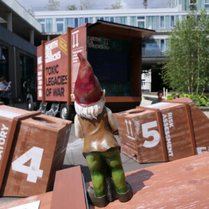 North Sea Wrecks: Communication concept for children: Gulliver, the garden gnome, tells children the story of the North Sea Wrecks project (NSW). Here he explores the NSW exhibition. Photo: Cornelia Riml A garden gnome inspects numbered wooden crates.
