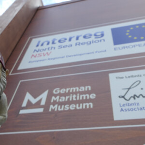 North Sea Wrecks: Communication concept for children: Gulliver, the garden gnome, tells children the story of the North Sea Wrecks project (NSW) and the EU support. Photo: Cornelia Riml Interreg project logo on big wooden box with garden gnome stood in front.