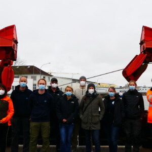 North Sea Wrecks: 5 women, 5 men. A bunch of different disciplines and nations enrich the research of the North Sea Wrecks Project in a wide range – all brought together by the EU support. Photo: Cornelia Riml Six people wearing face masks standing together on a pier, flanked by cranes.