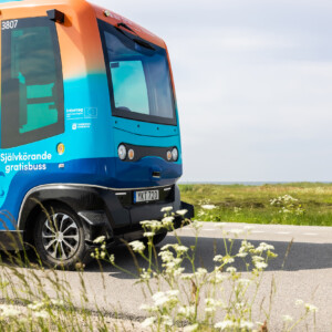 PAV: Helping cities to travel differently in the future. A blue and orange autonomous bus on the road